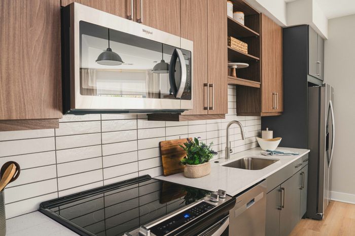 Close up of stainless steel appliances and custom white backsplash