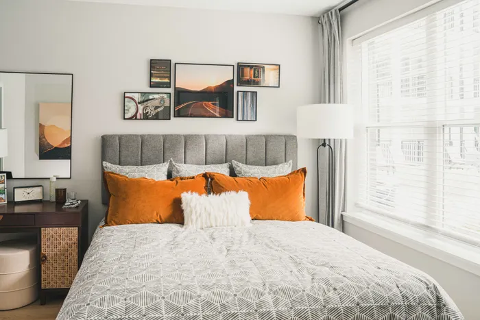 king sized bed with white bedding and orange pillows