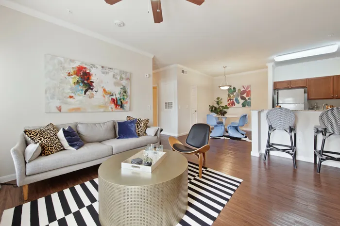 Open living area with large couch and ceiling fan