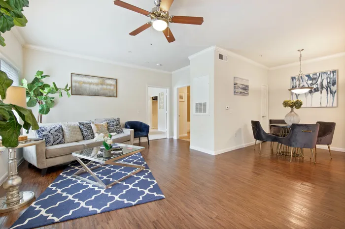 open concept living room with ceiling fan and hardwood style flooring