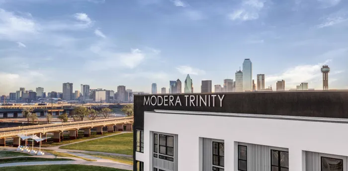 exterior of Modera Trinity Apartments with city views in the background
