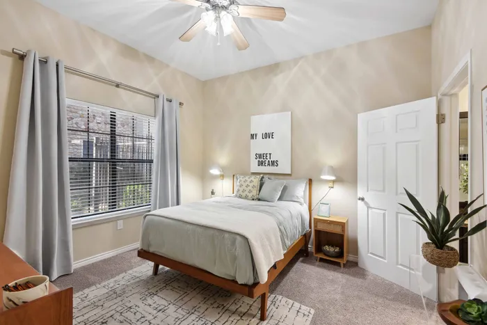 bedroom with large windows and ceiling fan alister sunset valley apartment homes for rent in austin tx