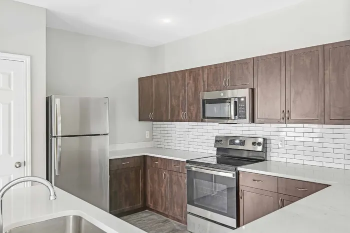 kitchen with light countertops and dark cabinets alister sunset valley apartment homes for rent in austin tx