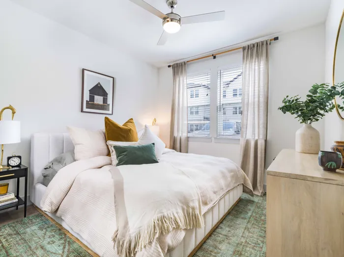 Large bedroom with wood-style flooring and large windows