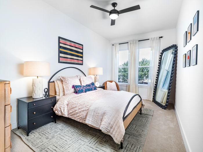 spacious bedroom with ceiling fan and modern decor
