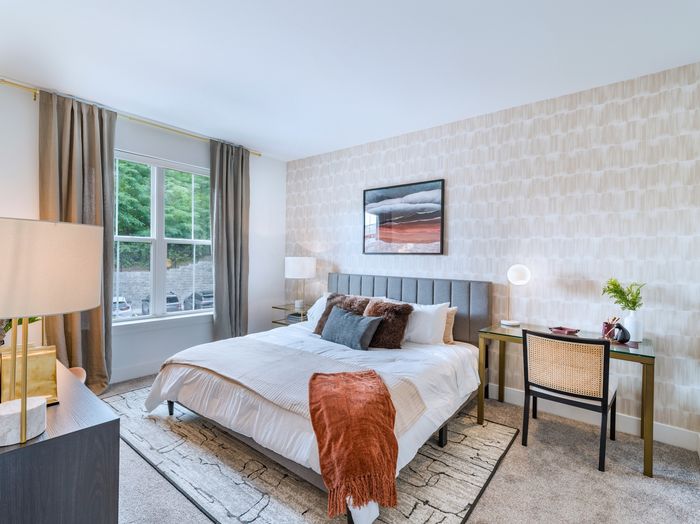 spacious bedroom with oversized windows and four pillar bed