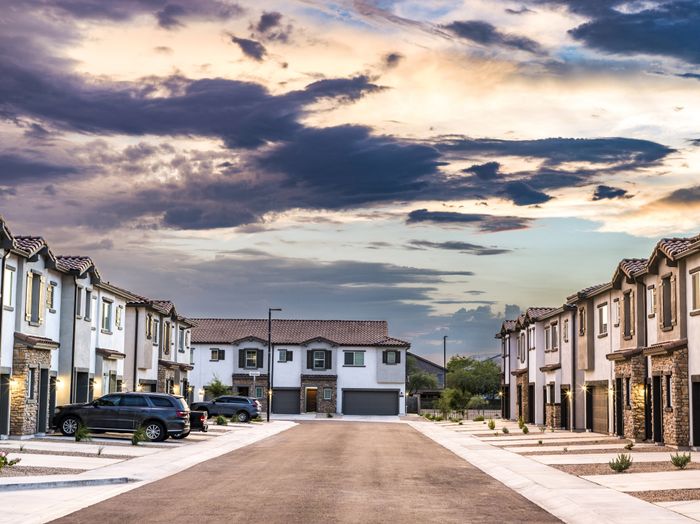 neighborhood street lined with sidewalk and townhomes at amavi aster ridge single family homes for rent in phoenix az