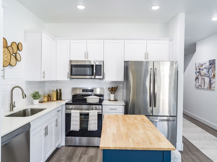 kitchen with white cabinetry and stainless steel appliances at amavi aster ridge single family homes for rent in phoenix az