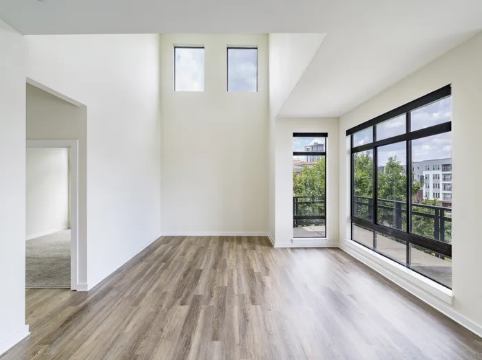 large windows in spacious living room looking onto adjoining room alister uptown apartment homes for rent in charlotte nc