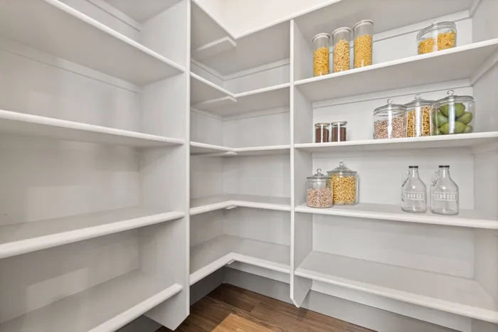 Large walk-in pantry with built-in shelving inside homes at Modern Craftsman Black Cat