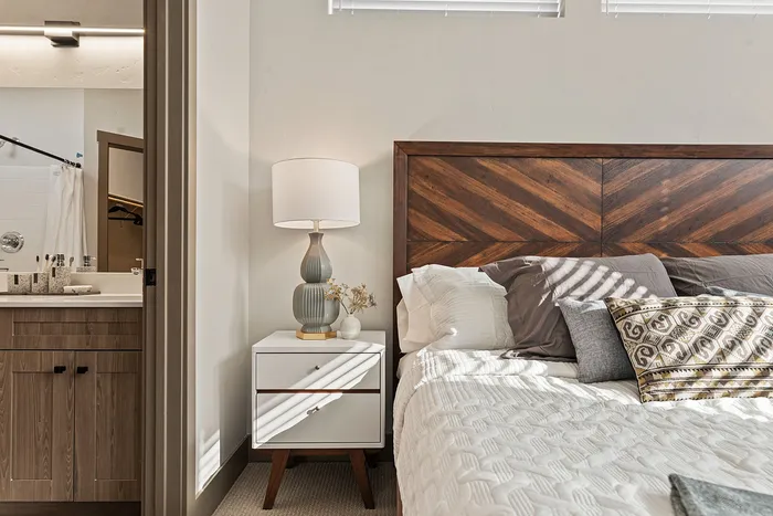 Modern furnishings inside primary bedroom in a model unit at Modern Craftsman Black Cat