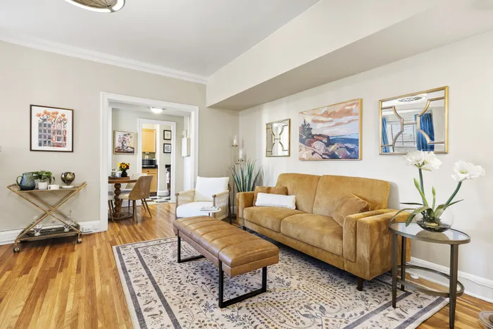 Charming living room with elegant decor, featuring a cozy mustard sofa, stylish coffee table, and artistic wall art in a well-lit space.