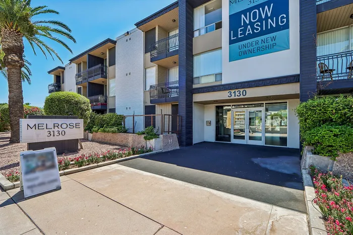 Contemporary apartment building with lush landscaping and prominent leasing sign at Melrose 3130.