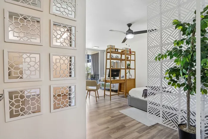 Chic apartment interior showcasing modern design elements with elegant patterned partitions, cozy seating area, and lush greenery.