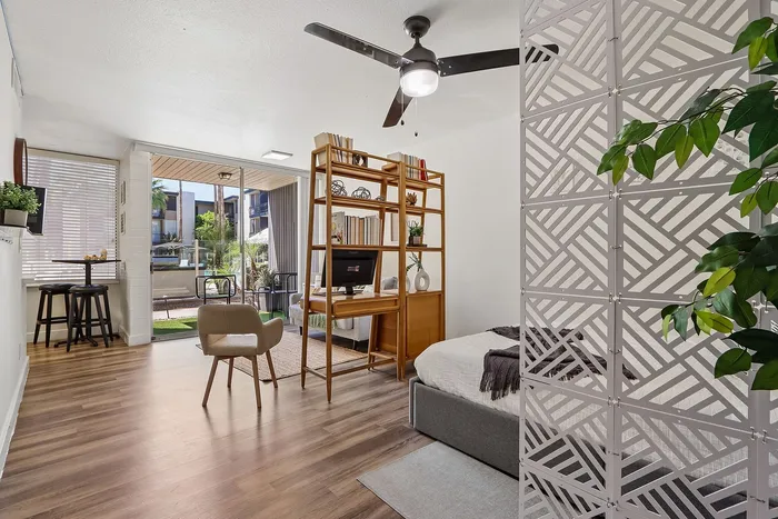 Bright and airy apartment showcasing an open-plan layout with a cozy bedroom nook, stylish living area, and a scenic balcony view.