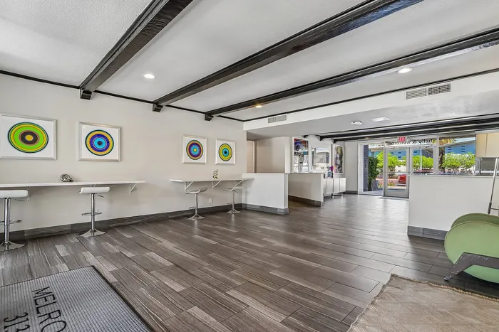 Modern lobby interior with sleek tile flooring, artistic wall decor, and contemporary seating area, providing a welcoming ambiance for residents.