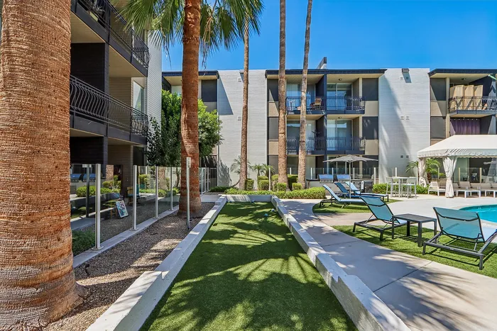 Luxurious apartment complex featuring modern balconies, lush greenery, and a stylish poolside area for relaxation.
