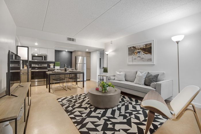 Sleek modern living area with stylish furniture, open kitchen, and inviting neutral tones.