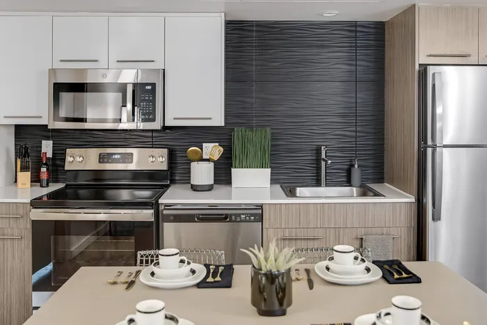 Contemporary kitchen with sleek stainless steel appliances, elegant backsplash, and a stylish dining setup for a modern lifestyle.