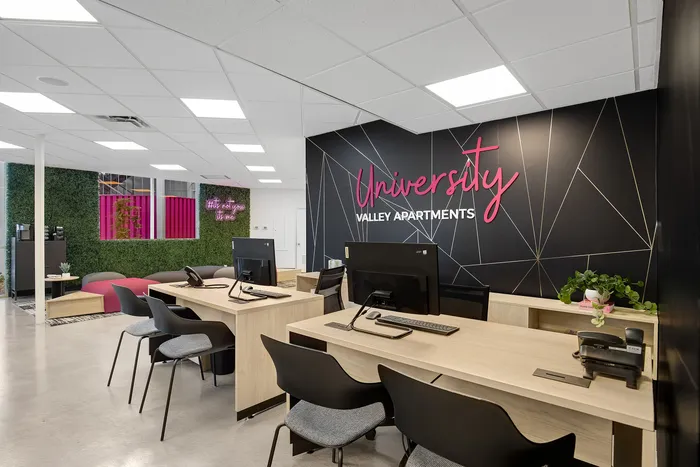 Modern and inviting office space at University Valley Apartments with contemporary decor and vibrant green wall.