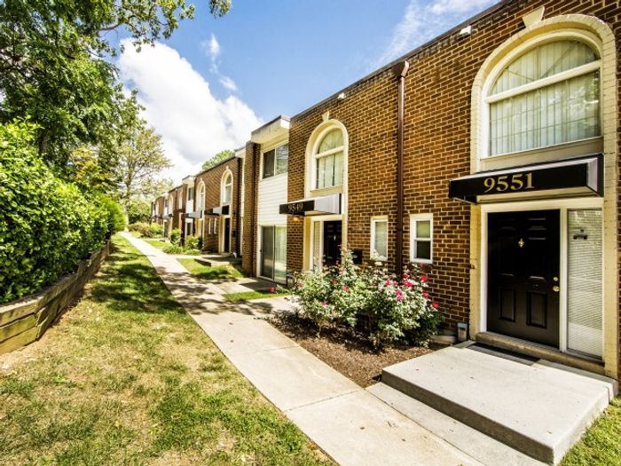 Apartments in Laurel MD - South Ridge Apartments Complex Exterior With Lush Green Landscaping And Rose Bushes Next To Walkway