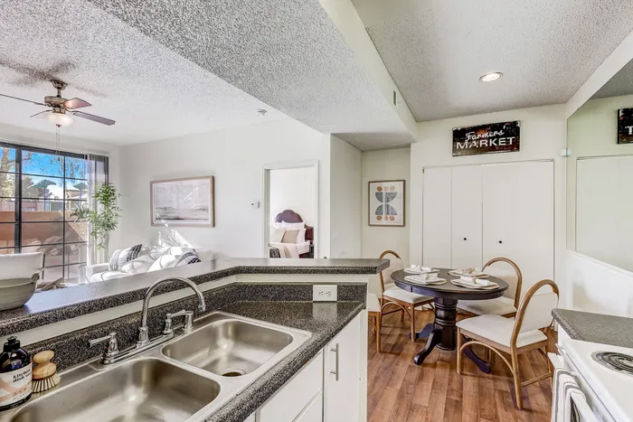 Apartments in North Las Vegas for Rent - Desert Ridge - Galley Kitchen with White Cabinetry, Grante Countertops, Wood Plank Flooring, and All White Appliances