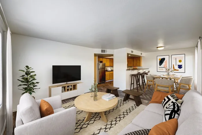 Pet-Friendly Apartments in West Las Vegas, NV - Portola Del Sol Apartment Homes - Bedroom With Green Throw Blanket, Large Window With Vertical Blinds, Accent Chair, And Wooden Desk.