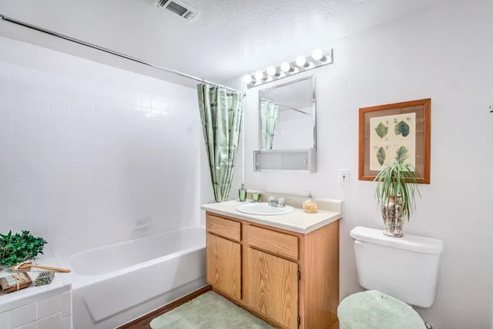 Las Vegas Apartments-Portola Del Sol Apartments Bathroom Mirror With Vanity Lighting And Tub With Square Tile