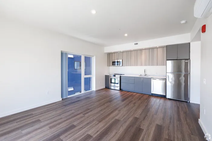 Dog-Friendly Apartments in West Oakland, CA - Prescott Station - Open-Concept Kitchen Features Two-Toned Cabinetry, Wood-Style Flooring, Stainless Steel Appliances, And Ceiling Lights.