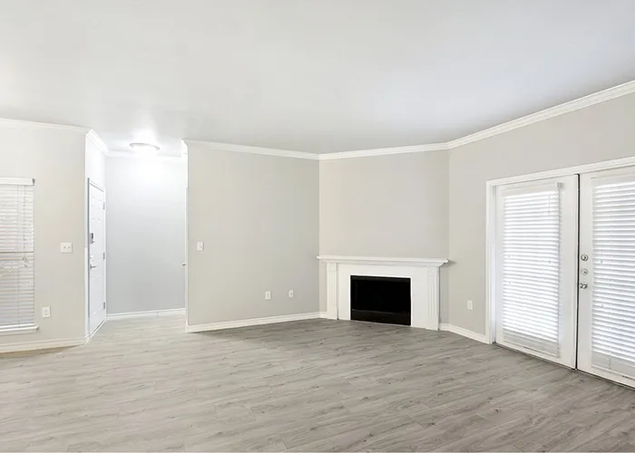 South Austin, TX, Apartments Near St. Edwards University - Saratoga Ridge - Open Living Room With Wood Style Flooring, White Fireplace Mantel, And Glass Patio Doors With Blinds.