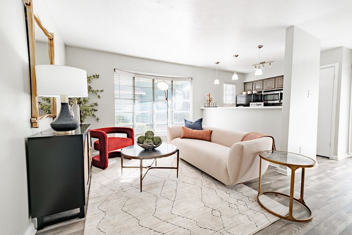 Dog-Friendly Apartments in North Dallas, TX - Ventana Apartment Homes - A Living Room With A Curved Cream Sofa, A Red Accent