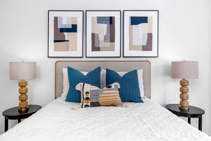2-Bedroom Apartments in West Chicago, IL - Timber Lake Apartment Homes - A Bedroom With Blue Accent Pillows, A Patterned Lumbar Pillow, And Matching Bedside Lamps.