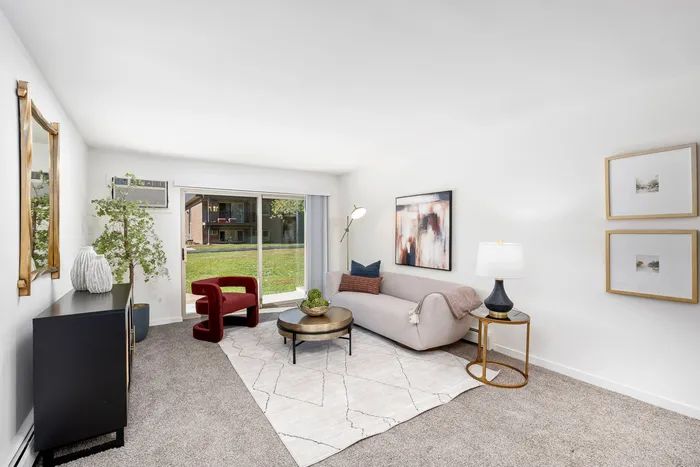 Two-Bedroom Apartments in West Chicago, IL - Timber Lake Apartment Homes - A Bright Living Room With A Light Gray Sofa, Round Coffee Table, Floor Lamp, and Wall Art.