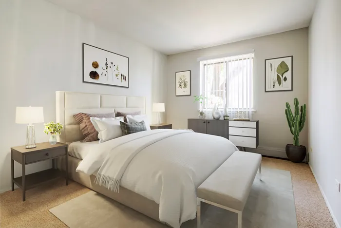 Two-Bedroom Apartments in Glendale Heights, IL - Ellyn Crossing Apartments - Bedroom With Upholstered Headboard, Crisp Bedding, Nightstand Lamps, and Sunny Window.