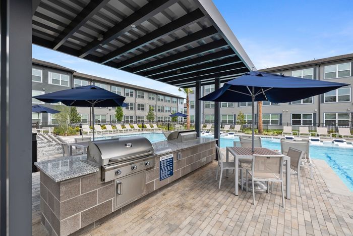 Outdoor grills and seating with blue umbrellas