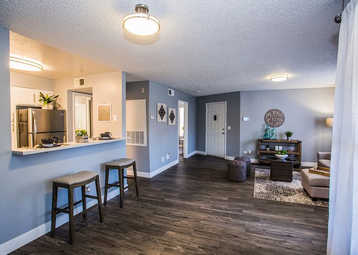 Welcoming open-concept living and kitchen area with modern decor and wood flooring.