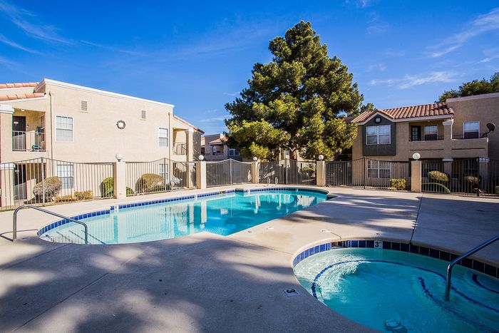 Inviting apartment complex with a sparkling swimming pool and a hot tub, surrounded by well-maintained landscaping.