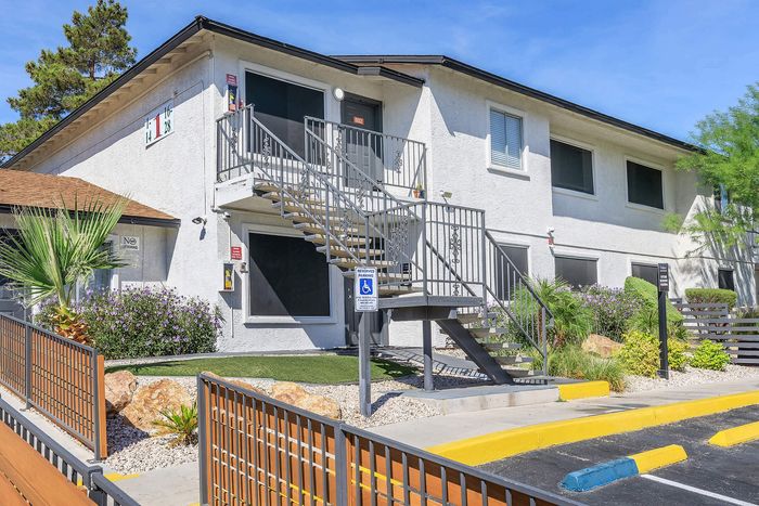 Modern two-story apartment building with stylish entrance and landscaped surroundings.