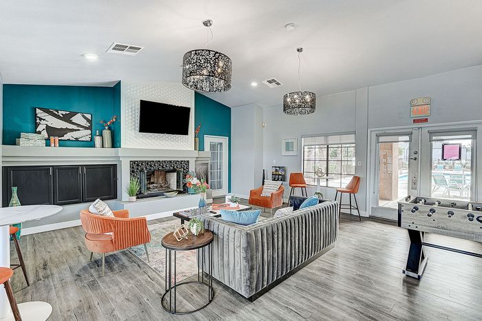 Elegant and contemporary open-concept living room with vibrant decor, featuring a cozy fireplace, stylish seating, and modern lighting, ideal for relaxation and entertainment.