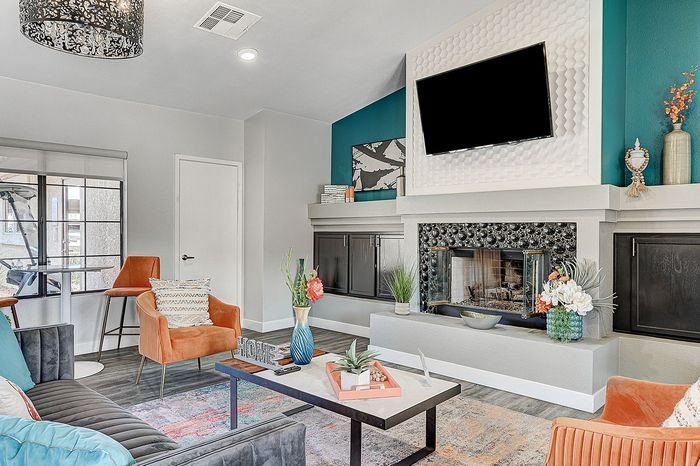 Contemporary living room featuring stylish decor, modern fireplace, and cozy seating with vibrant accents.