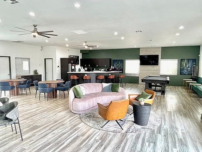 Modern and spacious open-concept living area with stylish seating, sleek flooring, and a chic kitchen bar, perfect for entertaining.