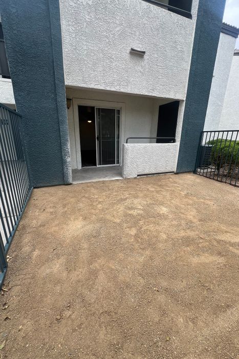 Inviting ground-floor apartment with private patio, sliding glass door entrance, and stylish stucco exterior.