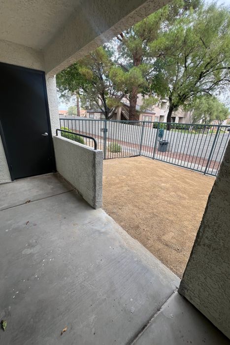 Inviting patio space with secure fencing and views of lush green trees, perfect for relaxing and enjoying the outdoors.