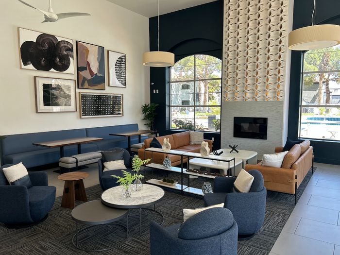 Elegant lounge area with modern decor, featuring cozy seating, stylish artwork, and large windows offering a pool view.