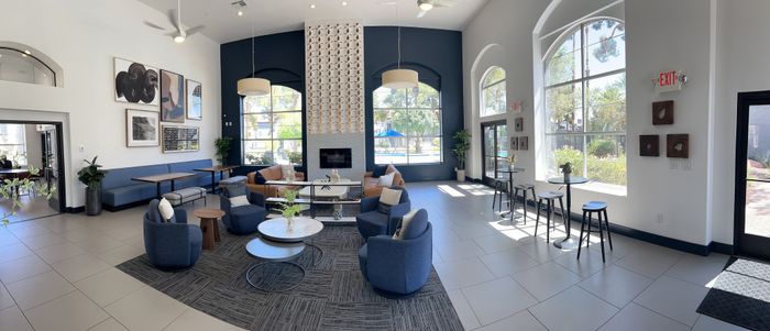 Elegant and spacious community lounge with modern decor, plush seating, large windows, and stylish artwork creating a welcoming atmosphere.