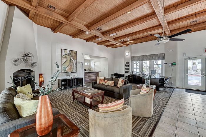 Spacious and inviting living room with stylish wooden ceiling beams, modern decor, and cozy seating area perfect for relaxation.