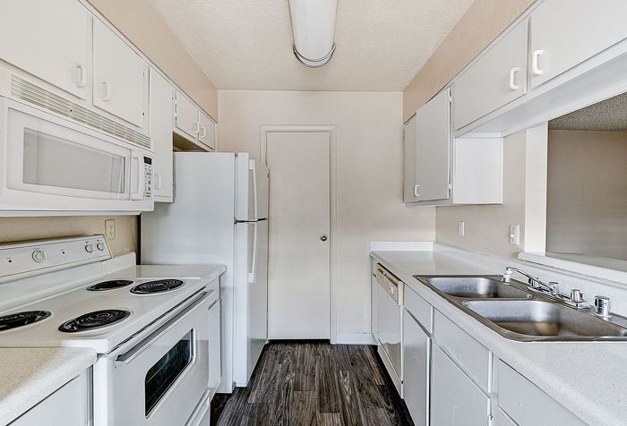 Bright and modern kitchen with sleek white cabinets, updated appliances, and a spacious countertop.