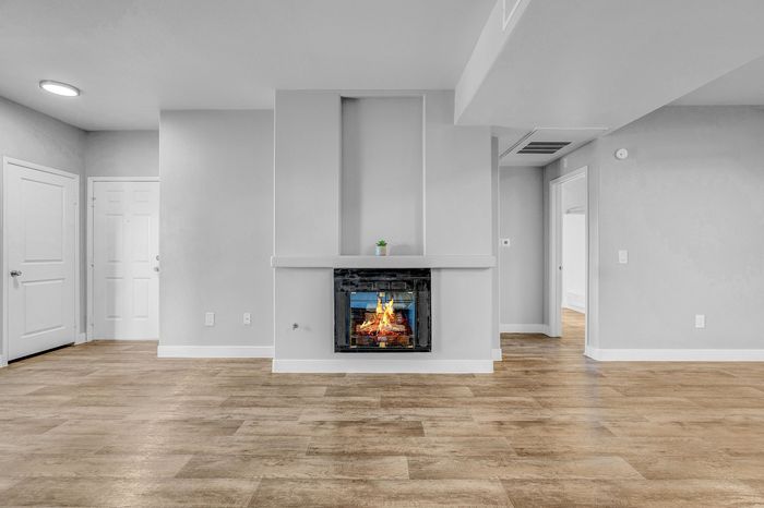 Charming apartment interior featuring a cozy fireplace, elegant hardwood floors, and sleek modern walls, inviting warmth and style.