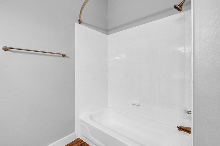 Chic bathroom showcasing an elegant white tiled shower with modern fixtures, perfect for relaxation.