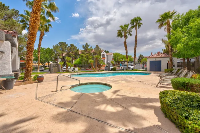 Inviting outdoor pool area with lush palm trees, cozy lounge chairs, and a serene ambiance perfect for relaxation.